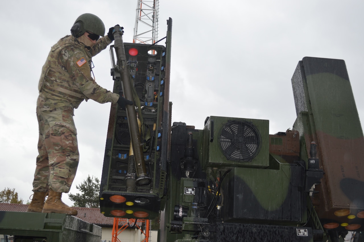 A soldier loads a missile into a short-range air defense missile system.