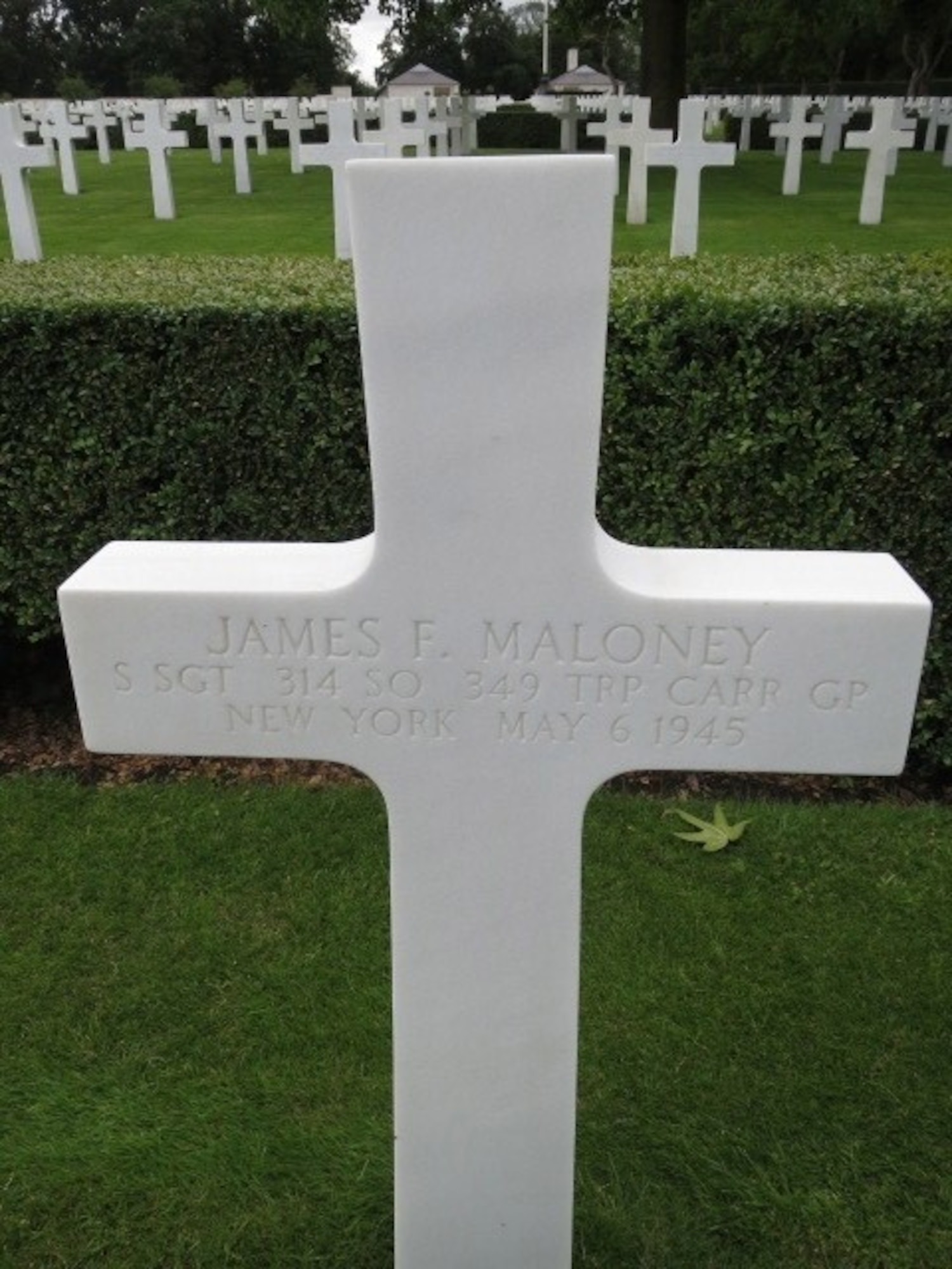 A marble white cross signifies the final resting place of Staff Sgt. James F. Maloney in England.
