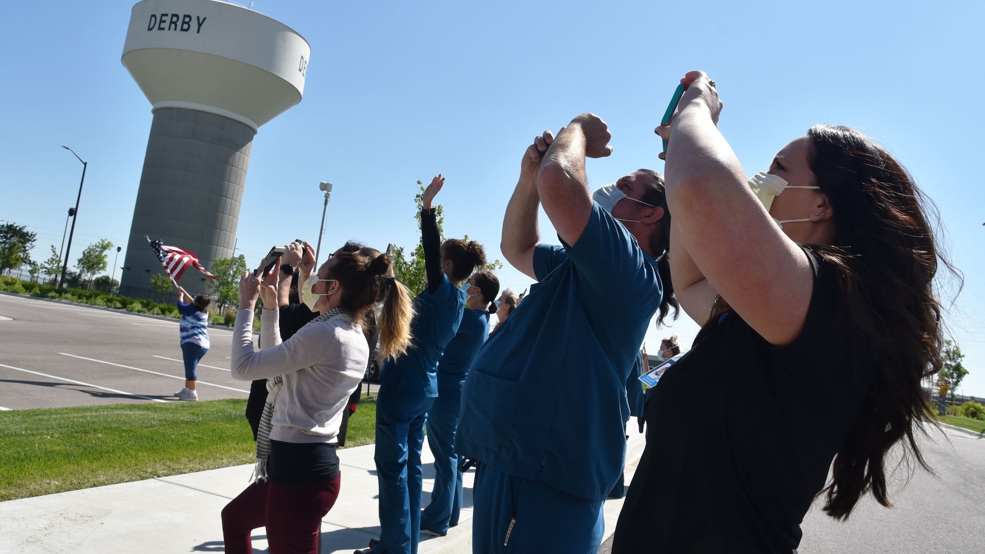 Healthcare Workers from Derby Rock Regional Hospital take photos of the McConnell Total Force formation flyover over May 6, 2020, at Wichita, Kansas.  The flyover, which included one KC-46A Pegasus and two KC-135 Stratotankers, consisting of 931st and 22nd Air Refueling Wing aircrews, and the B-29 Stratofortress known as 'Doc,' flew over 11 other local area hospitals to show appreciation for essential personnel on the front lines of COVID-19.  (U.S. Air Force photo by Tech. Sgt. Abigail Klein)