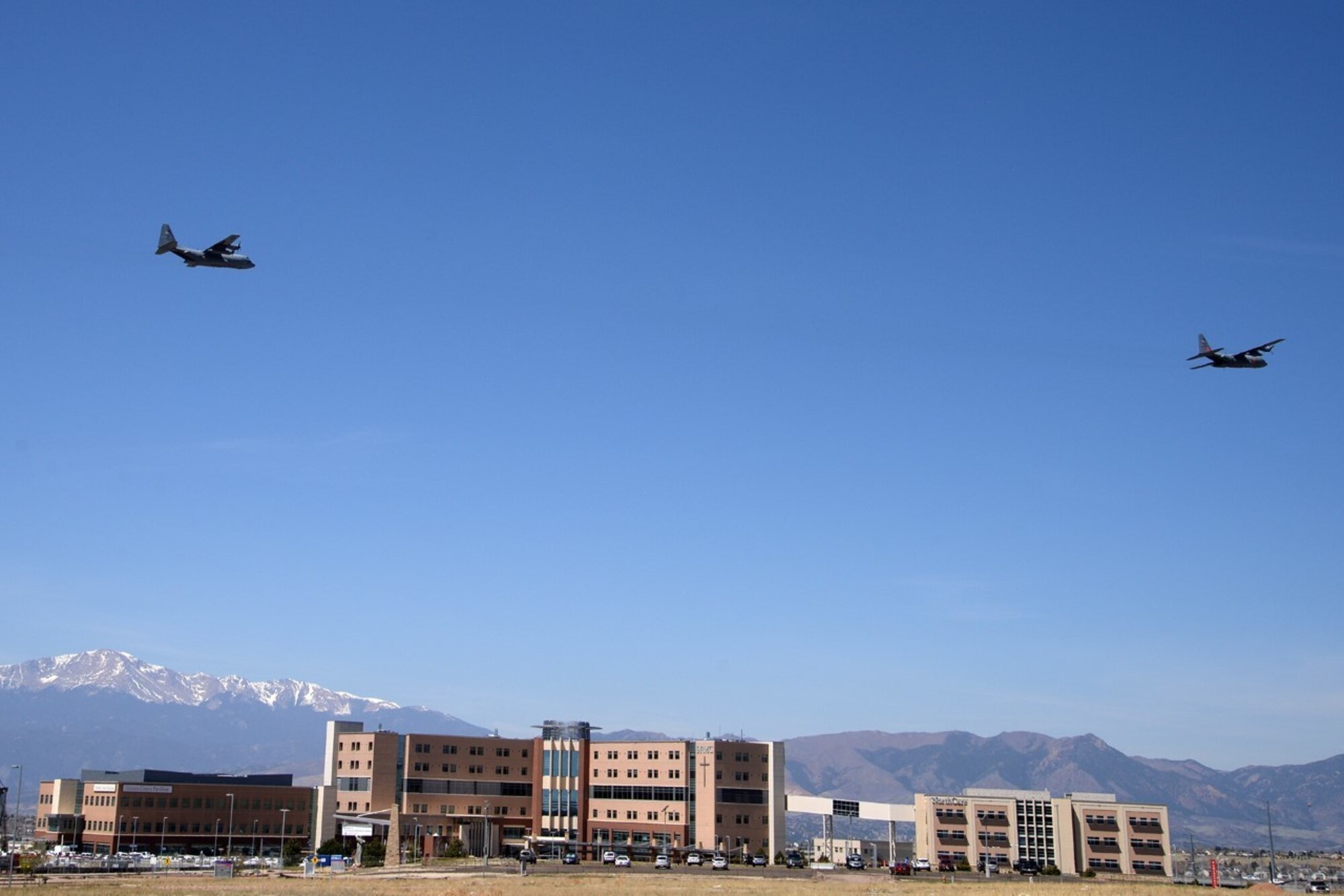 Image shows two large aircraft flying over Colorado Springs hospital