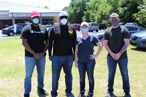 Photos shows four individuals standing together for a photo.