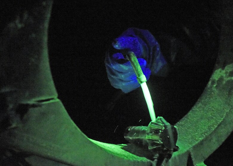 Photo of fluorescent liquid being poured onto an aircraft part.