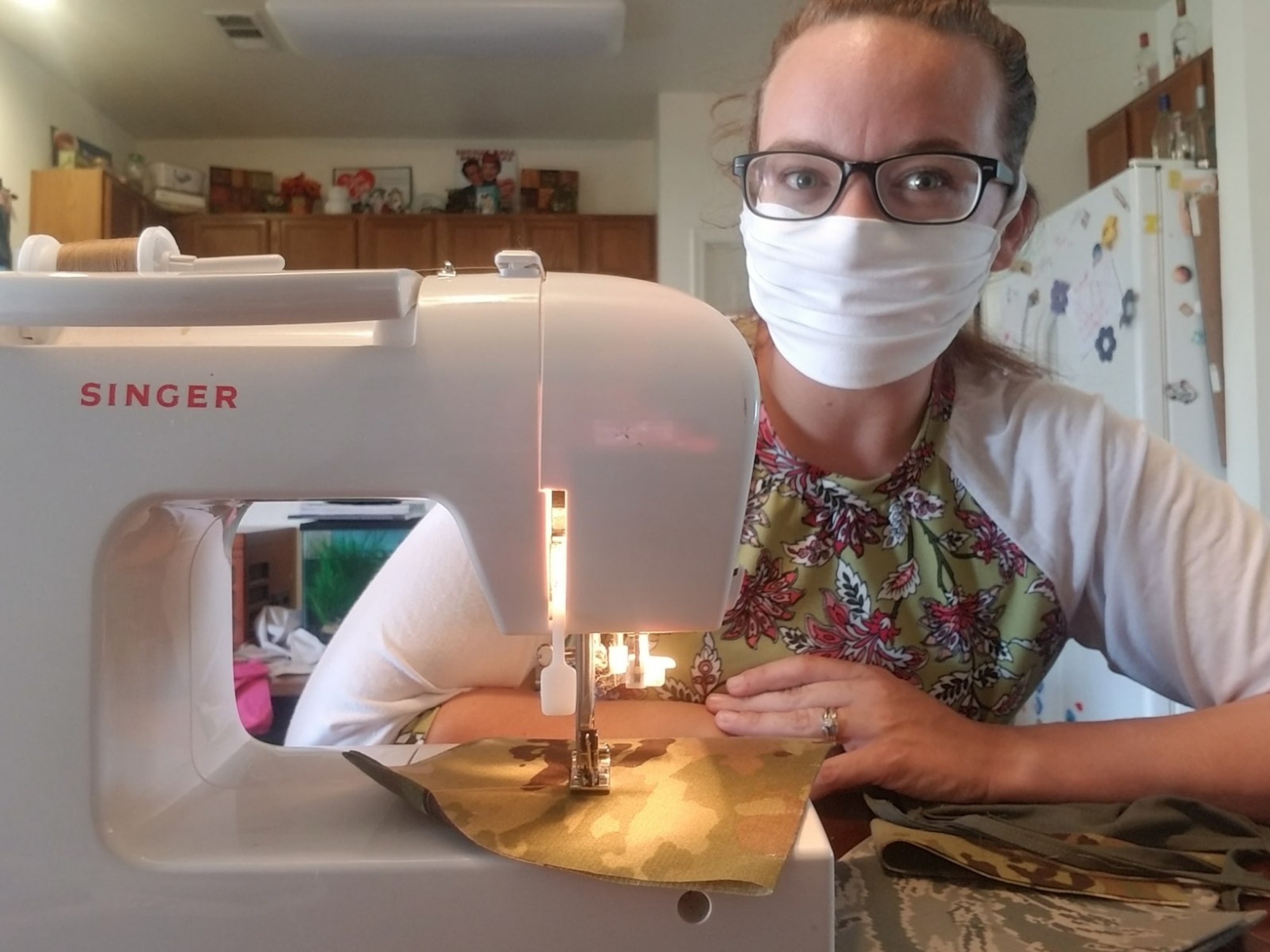 Jenn Taylor sits with her sewing machine at her home on Travis Air Force Base, California. Since Department of Defense guidance directed the use of face coverings April 3, 2020, Taylor has sewn more than 325 masks for members of the military community, all while caring for her three children while her spouse is on a yearlong deployment. (Courtesy photo)