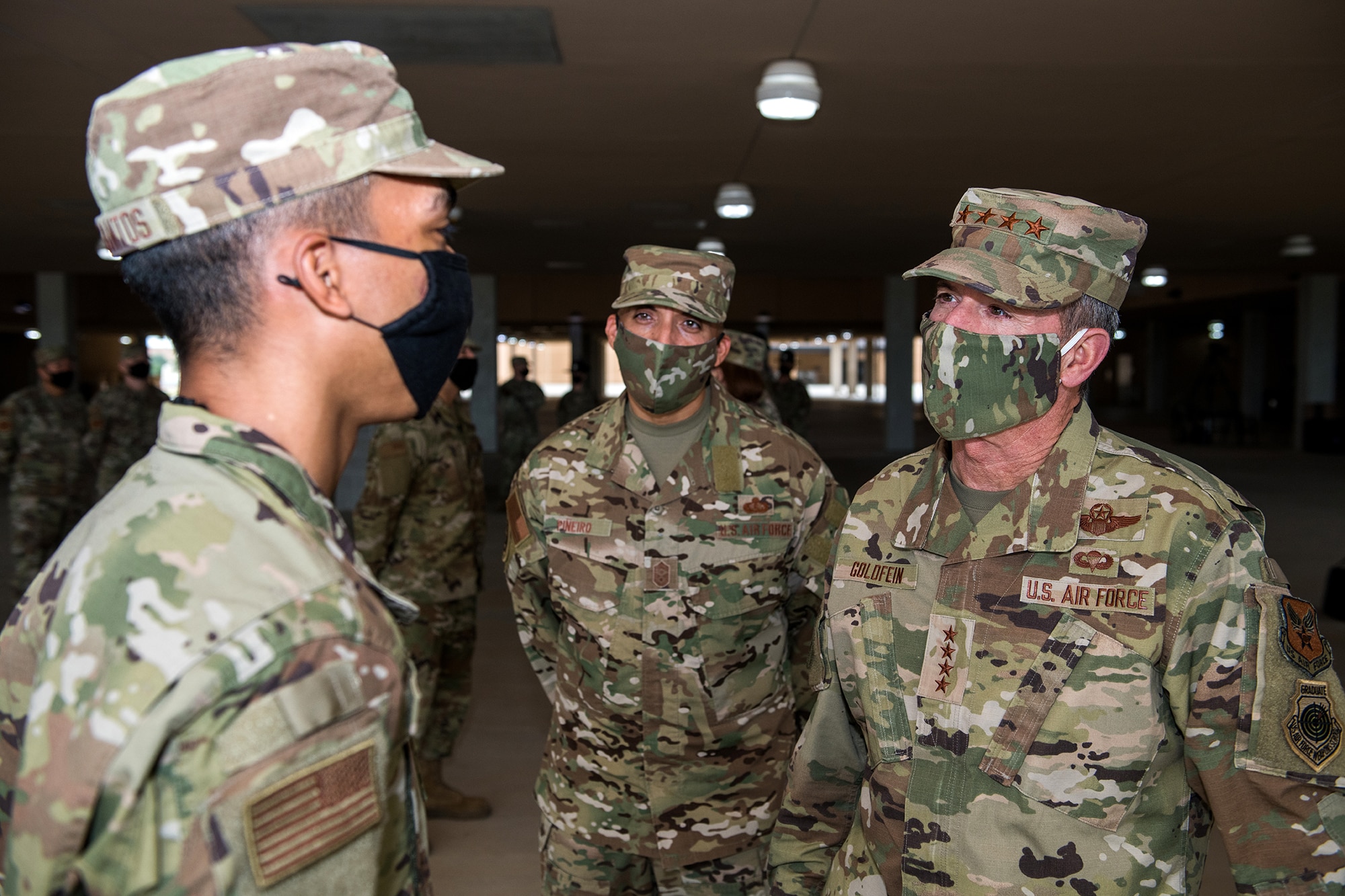 Air Force Chief of Staff Gen. David L. Goldfein (right) and Chief Master Sgt. Manny Pineiro (center), the service's first sergeant special duty manager, talks with an Airman after basic military training graduation May 7, 2020, at Joint San Antonio-Lackland, Texas.