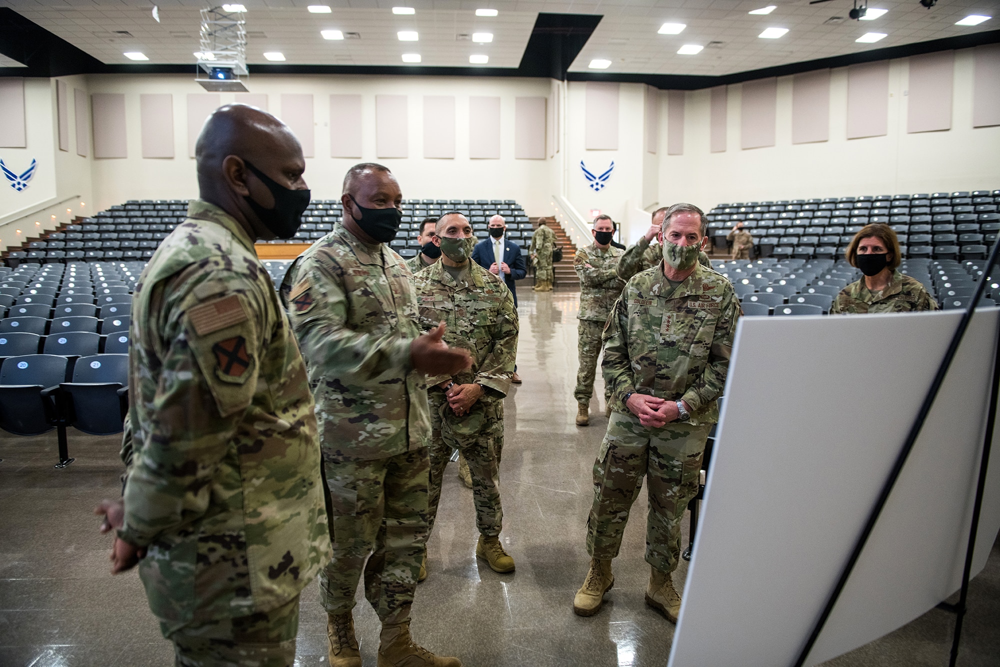 Air Force Chief of Staff Gen. David L. Goldfein (second from right) and Chief Master Sgt. Manny Pineiro (center), the service's first sergeant special duty manager, listen as Col. Michael Newsome, 737th Training Group and BMT commander, discusses current BMT COVID-19 mitigation procedures May 7, 2020, at the Pfingston Reception Center at Joint Base San Antonio-Lackland, Texas.