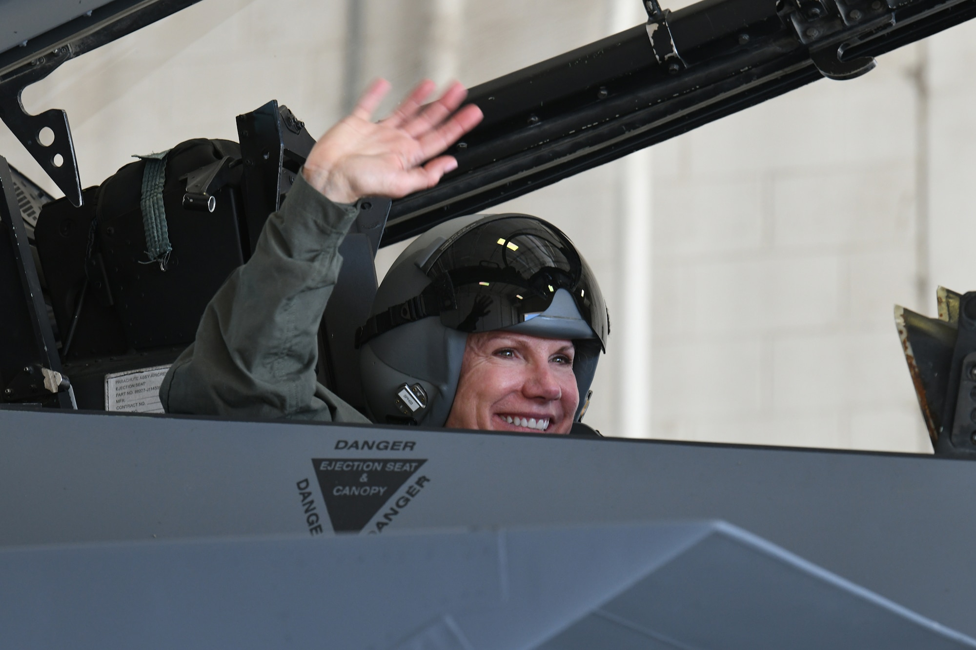 Photo shows Col. Farrell in the cockpit of an F-15 aircraft waving.