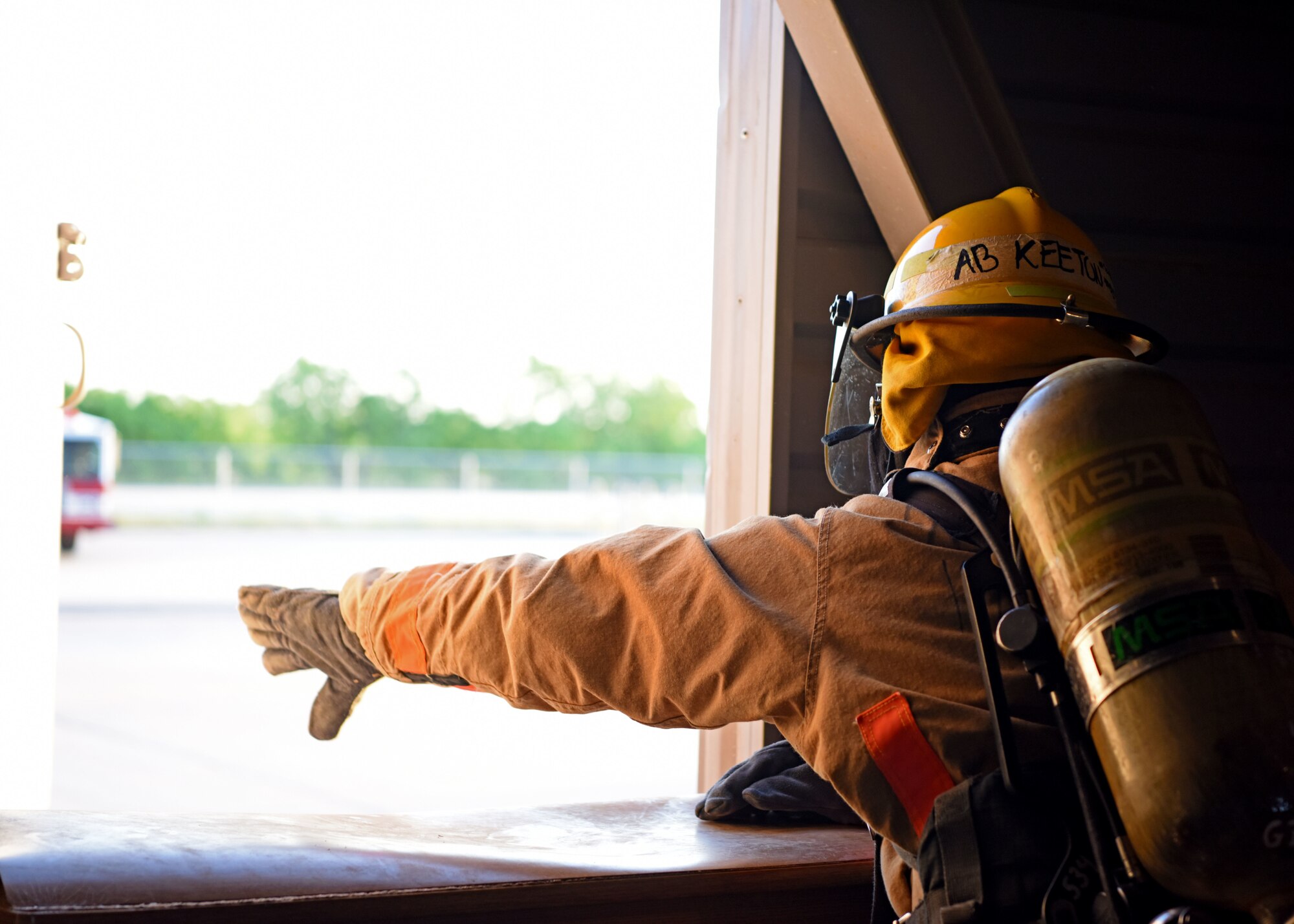 A 312th Training Squadron student pushes open a window to ventilate a building at the Louis F. Garland Department of Defense Fire Academy on Goodfellow Air Force Base, Texas, May 7, 2020. The rescue team was fitted with blindfolds to simulate smoke, they were then sent in to ventilate the building to dissipate the simulated smoke. (U.S. Air Force photo by Airman 1st Class Ethan Sherwood)