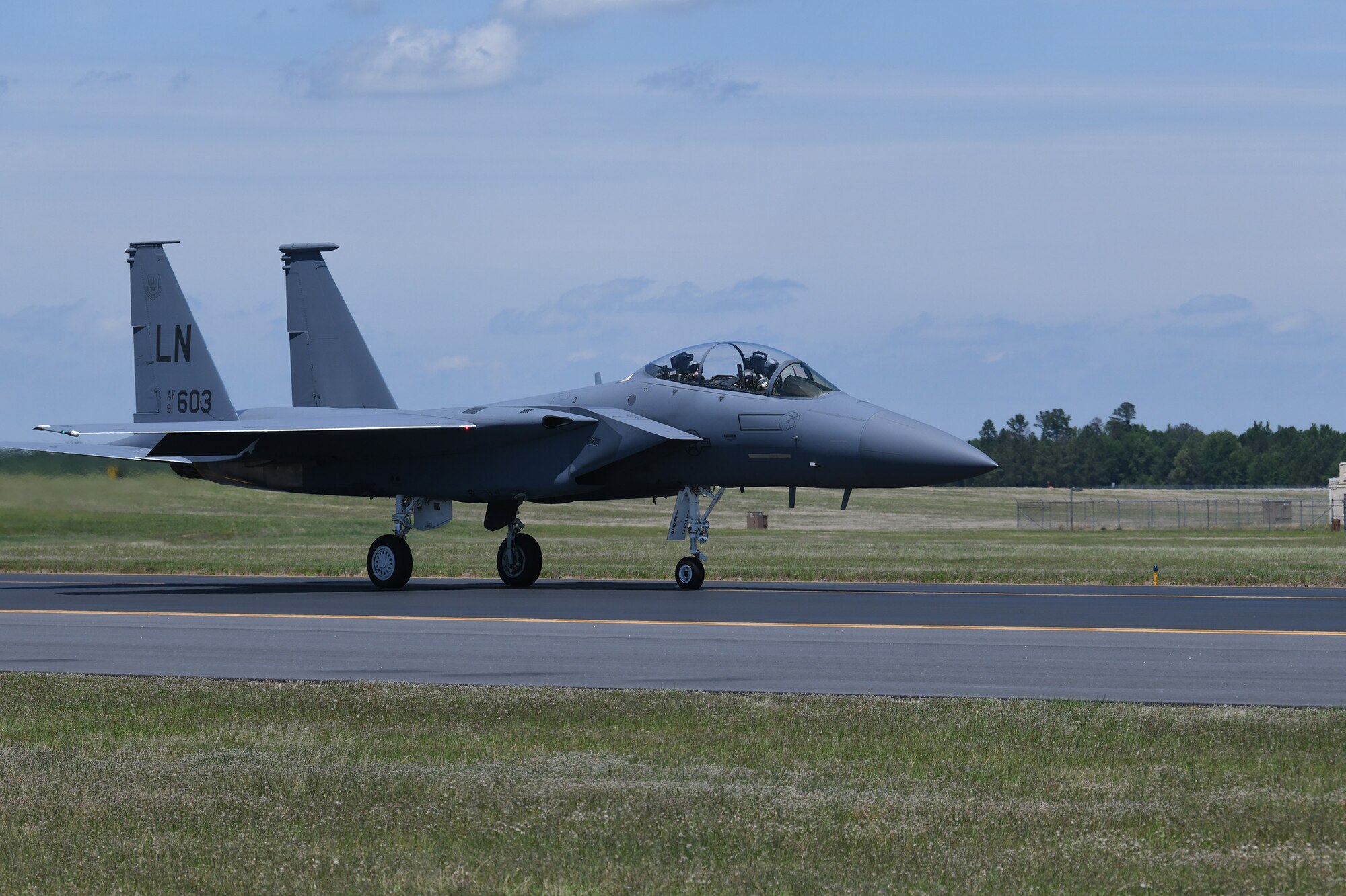 Photo shows an F-15 aircraft on the flight line.