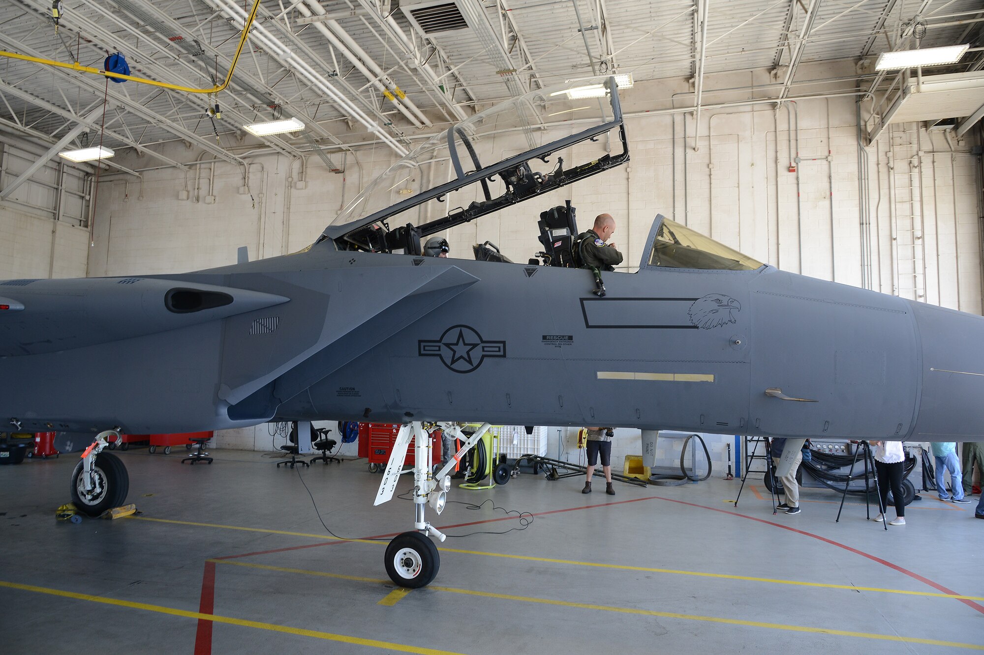 Photo shows two individuals in the cockpit of an F-15.