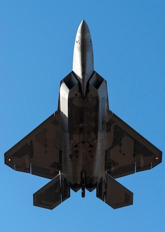 A U.S. Air Force F-22 Raptor flies over Joint Base Elmendorf-Richardson, Alaska, following a close formation taxi known as an elephant walk, May 5, 2020. This event displayed the ability of the 3rd Wing, 176th Wing and the 477th Fighter Group to maintain constant readiness throughout COVID-19 by Total Force Integration between active-duty, Guard and Reserve units to continue defending the U.S. homeland and ensuring a free and open Indo-Pacific.