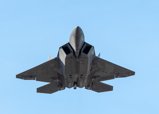 A U.S. Air Force F-22 Raptor flies over Joint Base Elmendorf-Richardson, Alaska, following a close formation taxi known as an elephant walk, May 5, 2020. This event displayed the ability of the 3rd Wing, 176th Wing and the 477th Fighter Group to maintain constant readiness throughout COVID-19 by Total Force Integration between active-duty, Guard and Reserve units to continue defending the U.S. homeland and ensuring a free and open Indo-Pacific.