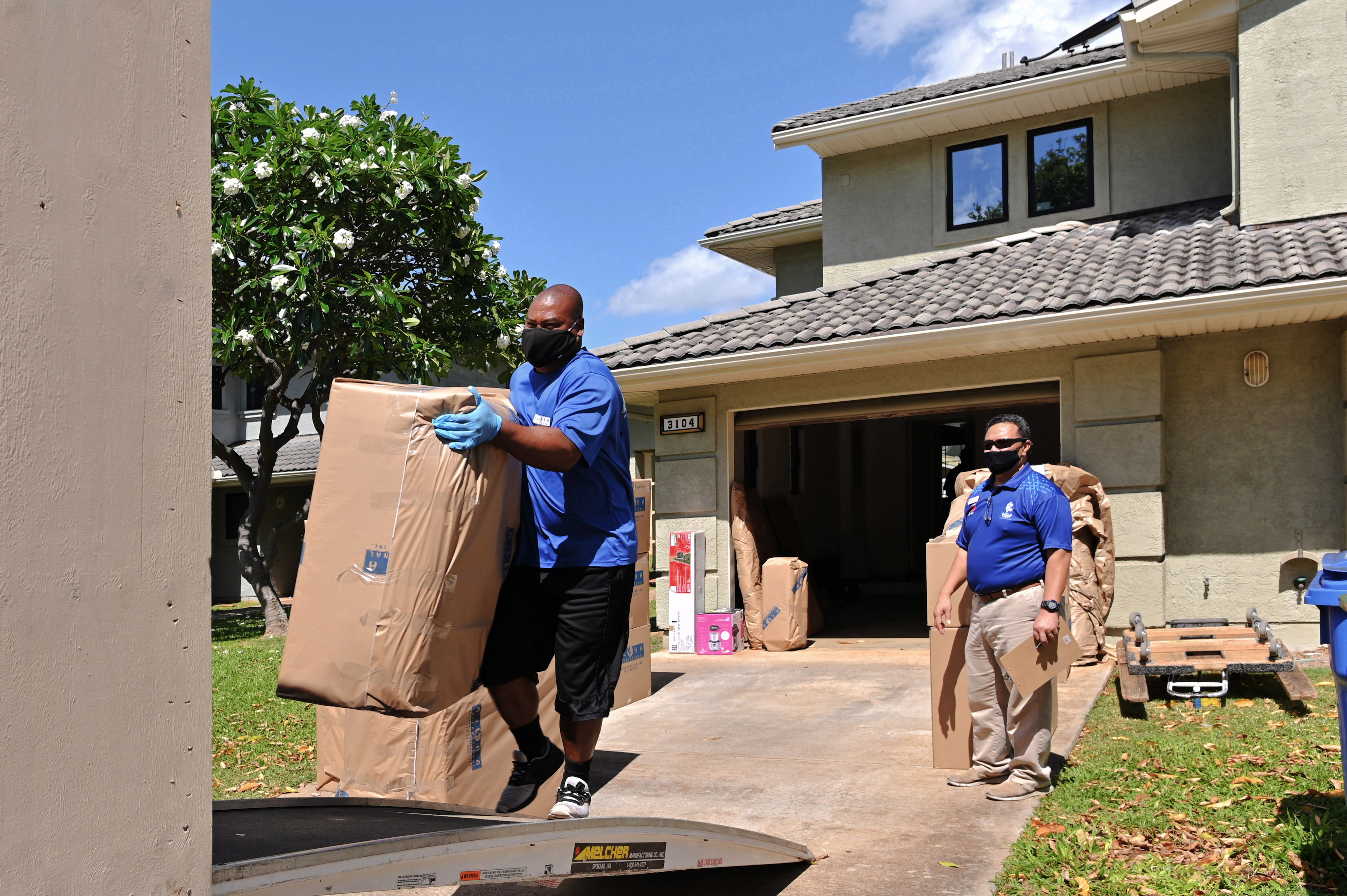 Household goods inspector Faata Leafa performs an inspection of a household goods packout performed by Aloha International. They all are practicing social distancing and wearing facemasks.