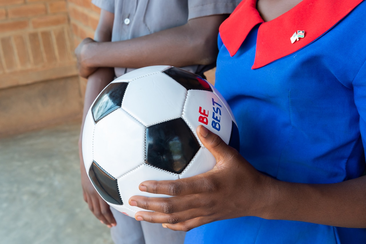A girl holds a soccer ball.