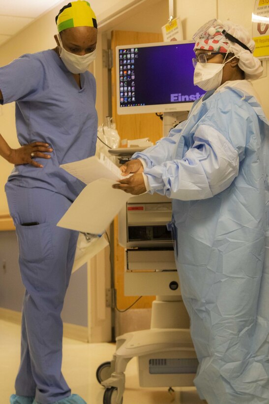 U.S. Army Capt. Jody Reid, a medical-surgical nurse, assigned to Urban Augmentation Medical Task Force 352-1, talks to medical staff at Einstein Medical Center, Philadelphia, Pa., May 2, 2020. UAMTF 352-1 deployed to the Philadelphia area to assist federal and state agencies at multiple local hospitals to combat COVID-19. U.S. Northern Command, through U.S. Army North, remains committed to providing flexible Department of Defense support to the Federal Emergency Management Agency for the whole-of-nation COVID-19 response. (U.S. Army photo by Spc. Joshua Cowden, 22nd Mobile Public Affairs Detachment)