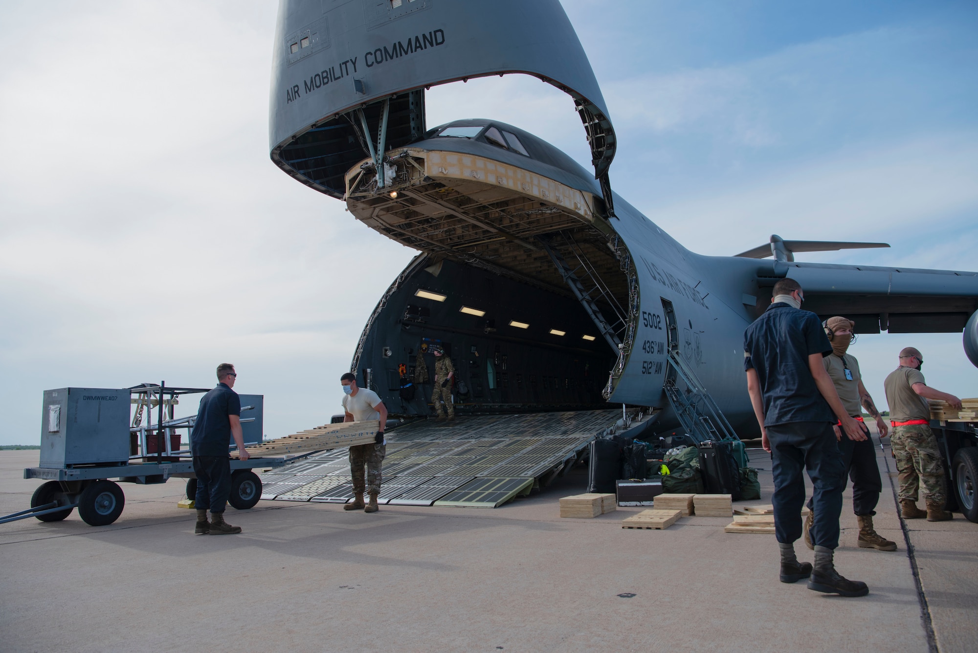 Airmen from the 7th Equipment Maintenance Squadron prepare ramps to load cargo onto a C-5 Galaxy assigned to Dover Air Force Base, Delaware, at Dyess AFB, Texas, April 27, 2020. The C-5 transported Bomber Task Force equipment for four B-1B Lancers and approximately 200 Airmen to Andersen AFB, Guam. The BTF supports Pacific Air Forces' training efforts with allies, partners and joint forces; and strategic deterrence mission to reinforce the rules-based international order in the Indo-Pacific region (U.S. Air Force photo by Airman 1st Class Nicole Molignano)