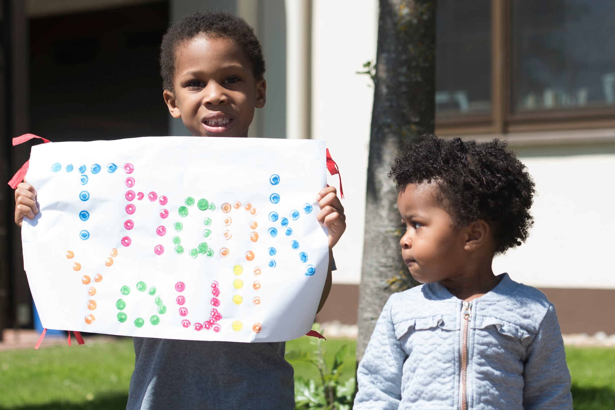 A photo of a child holding up a sign.