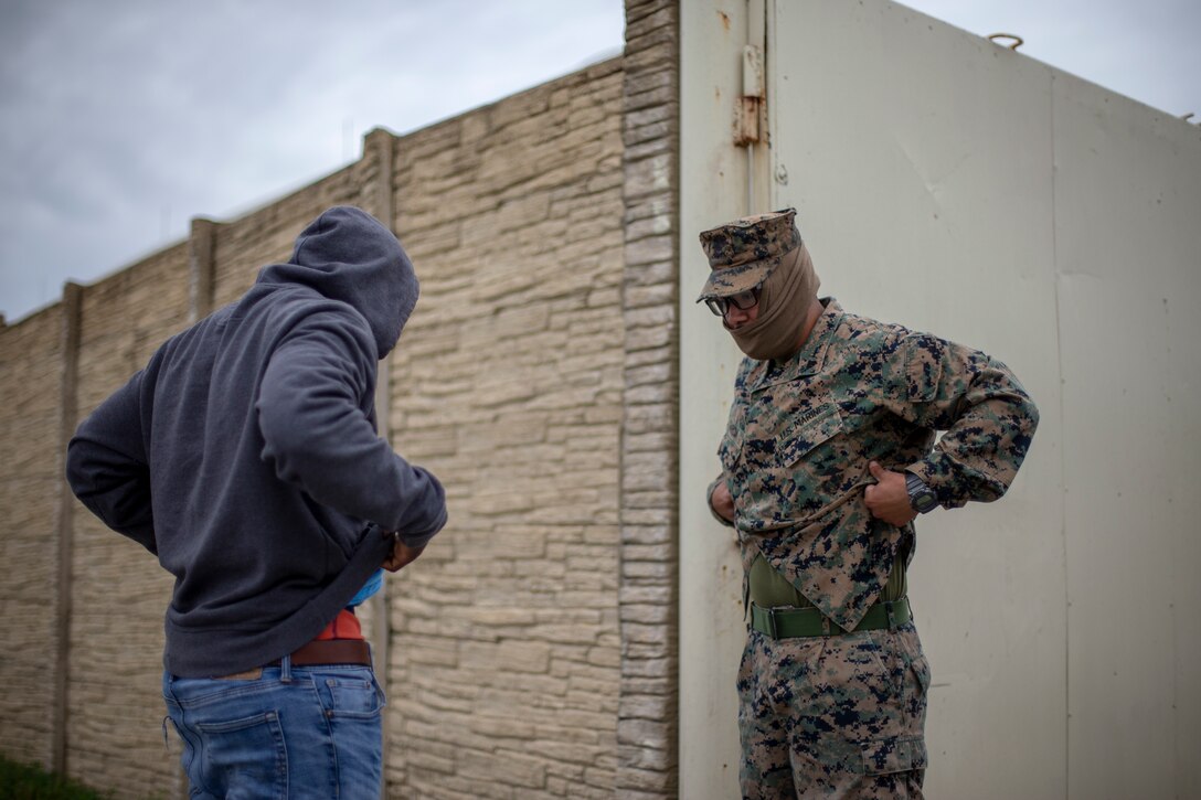A U.S. Marine searches a role-player during a training event.