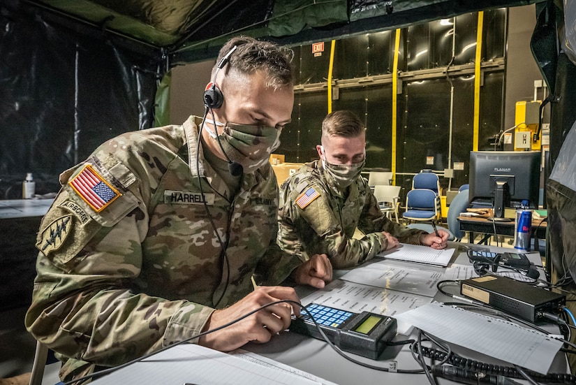 Masked soldiers do communications tasks.
