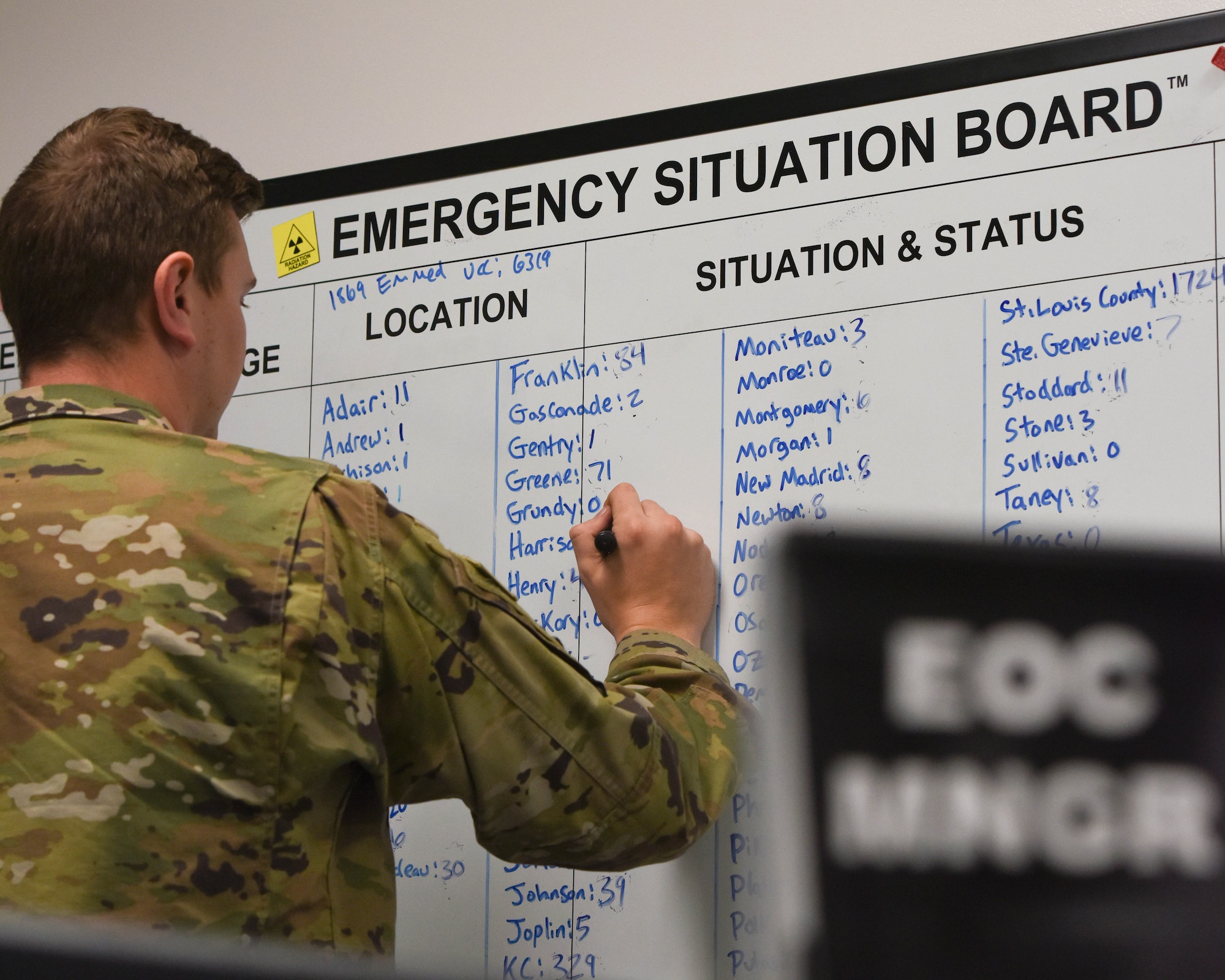 United States Air Force first lieutenant Austin Flues assigned to the 509th Bomb Wing Emergency Management Flight, as the readiness and emergency management flight commander, makes updates to a chart tracking COVID-19 virus data across Missouri.  Emergency management personnel operate out of the Emergency Operations Center when activated, to execute the Installation Emergency Response Plan which includes specific medical disease containment procedures and instructions.