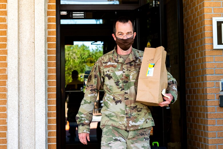 Photo of pharmacist carrying prescriptions to a patient.