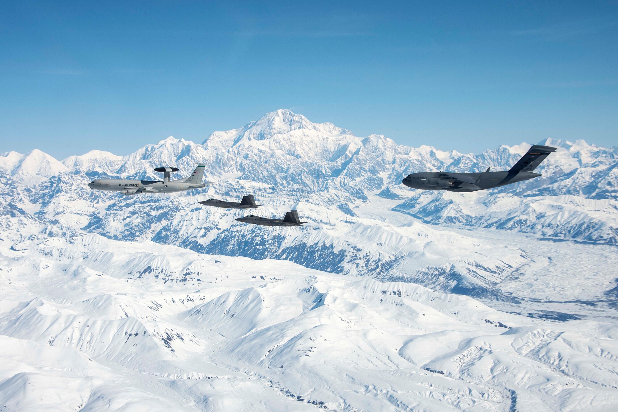 An E-3 Sentry, two F-22 Raptors and a C-17 Globetrotter assigned to Joint Base Elmendorf-Richardson fly over Alaska May 5, 2020.