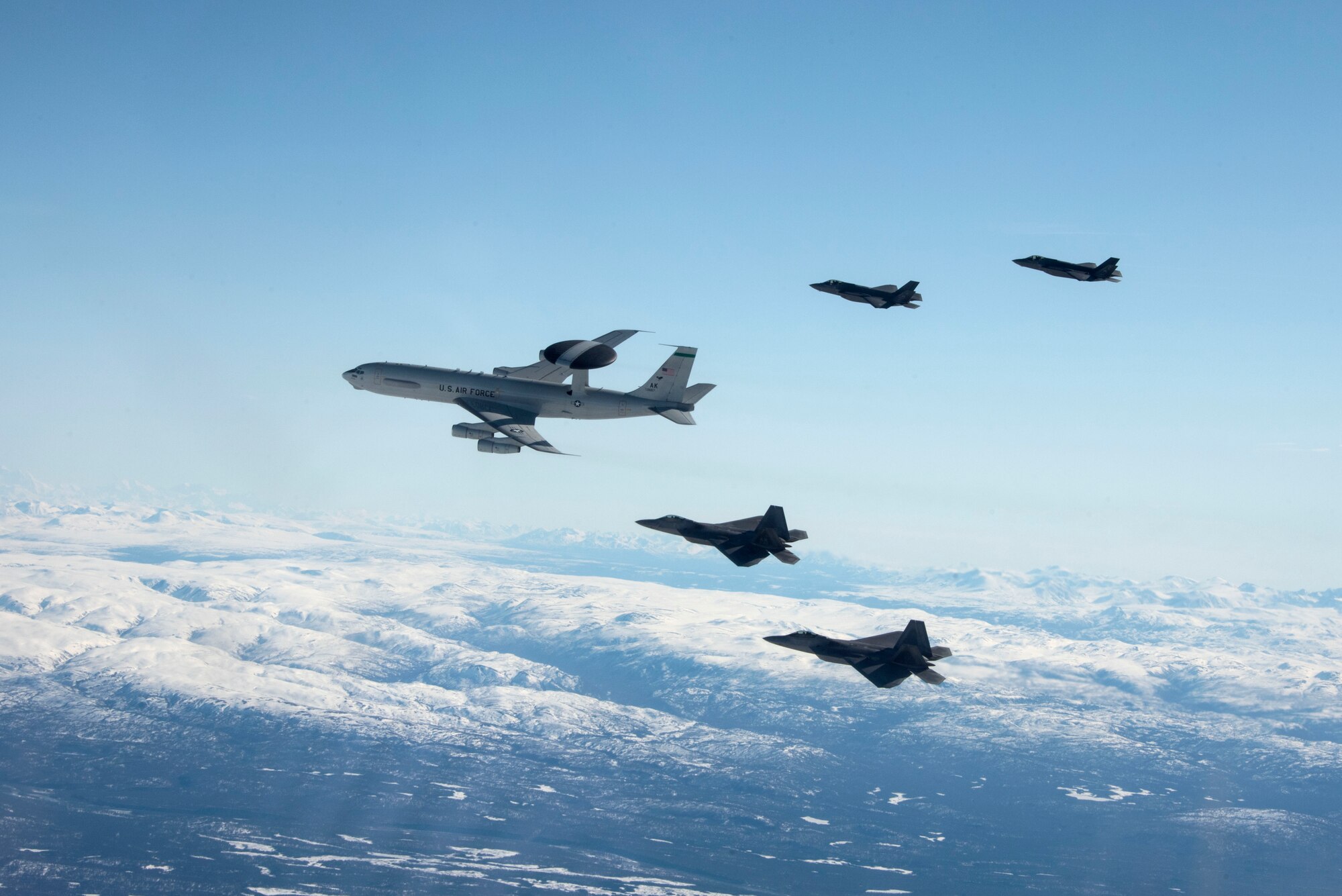 An E-3 Sentry, two F-22 Raptors and two F-35A Lightning IIs fly over Alaska May 5, 2020.