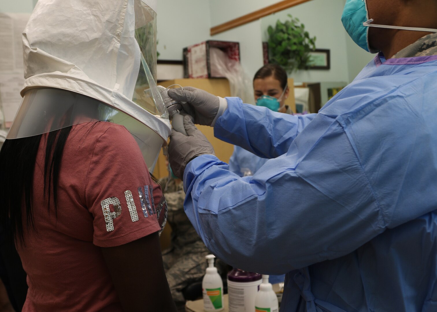 Airman 1st Class Traevonne Greene, 190th Air Refueling Wing, Kansas Air National Guard health service technician, sprays a non-toxic test solution into the hood of Latasha Benfer, medication aide for Homestead of Topeka, to test the N95 protective masks’ ability to filter airborne particles during a fit test demonstration at Homestead of Topeka in Topeka, Kansas, May 6, 2020.