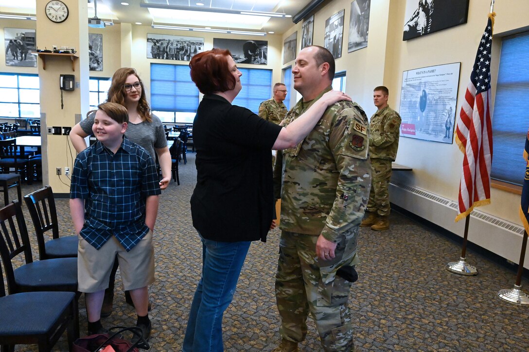 Photo of Chief Master Sgt. Josh Clarke, of the 119th Security Forces Squadron, being congratulated by his wife and family following his promotion ceremony at the North Dakota Air National Guard Base, Fargo, N.D., May 6, 2020.