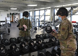 U.S. Air Force Tech. Sgt. Sharniece Clary, 9th Force Support Squadron fitness center program manager, sanitizes dumbbells in the Harris Fitness Center at Beale Air Force Base, California, May 6, 2020. The fitness center personnel disinfected every piece of equipment found in the facility while following Centers of Disease Control guidelines, and using standard Environmental Protection Agency approved disinfectants. (U.S. Air Force photo by Airman 1st Class Luis A. Ruiz-Vazquez)