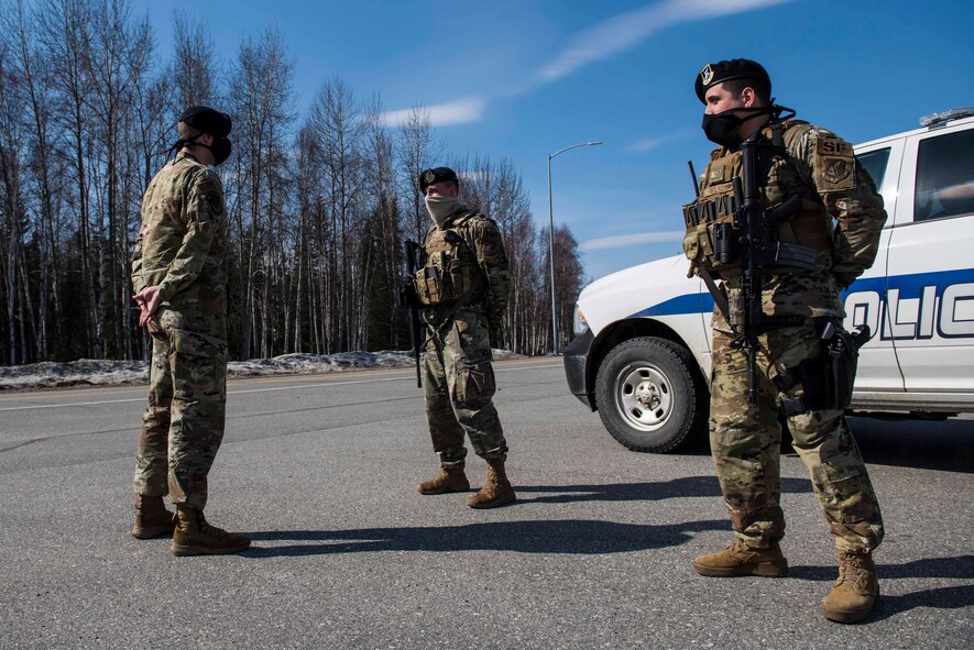 U.S. Air Force Tech. Sgt. Matthew R. Dobbins, the 354th Security Forces Squadron (SFS) non-commissioned officer in charge of operations, performs a post briefing with Senior Airman Cole Steele and Senior Airman Justin Wilson, 354th SFS response force officers, at Eielson Air Force Base, Alaska, April 28, 2020.