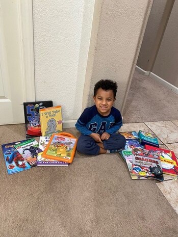 Dom Woodley smiles for the camera after receiving his books from the ‘Be a Book Hero’ campaign. May 8, 2020, Beale Air Force Base, California. The campaign provided an average of ten books per child across 37 AMMO families. (Courtesy photo, Staff Sgt. Anthony Woodley, 9th Munitions Squadron, munitions technician.)