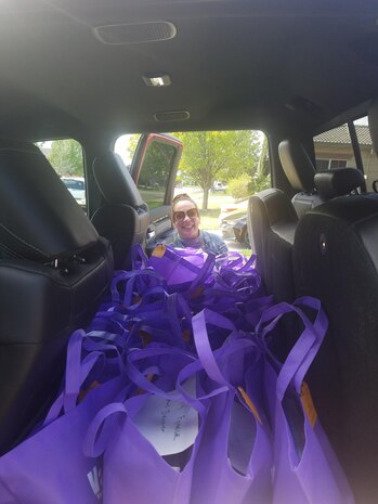 Jen Stamper poses with all the books donated by The Literacy Club. May 6, 2020, Beale Air Force Base, California. The club is a non-profit organization that initiated the ‘Be a Book Hero’ campaign meant to provide books to children who are at home during the pandemic. (Courtesy photo, Chief Master Sgt. Lonnie Stamper, 9th Munitions Squadron superintendent.)