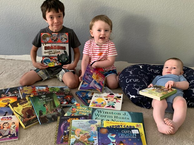 Jaxon, Cali and Crue Moore pose with their books from the, Be a Book Hero campaign, May 6, 2020, Beale Air Force Base, California. The campaign assisted in providing 700 books to children within the AMMO community (Courtesy photo, Master Sgt. Aaron S. Moore, 9th Civil Engineering Squadron, unaccompanied housing superintendent