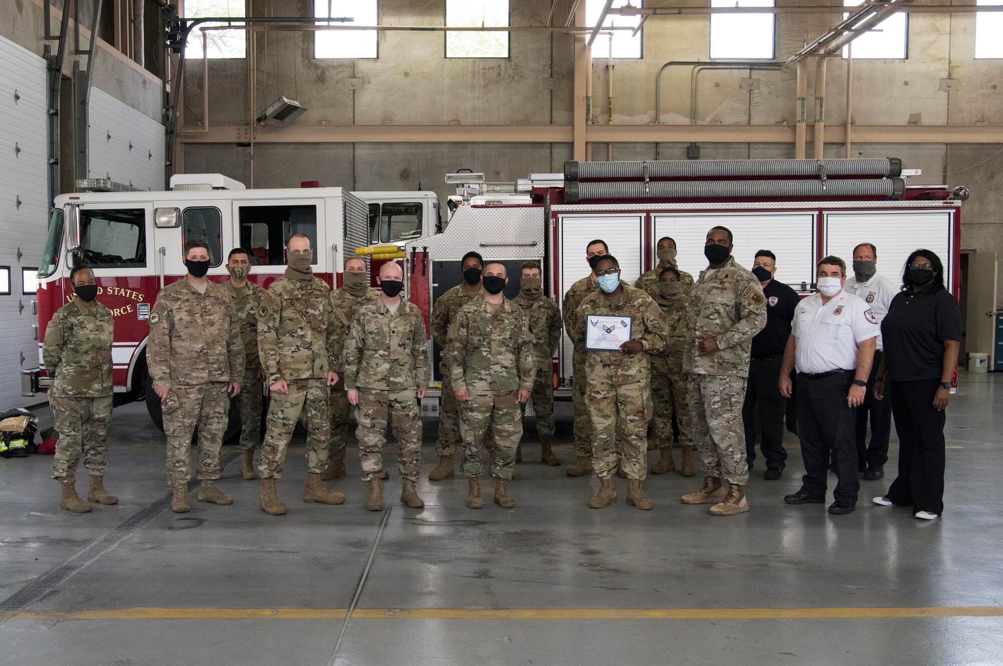Col. Lee Gentile, 47th Flying Training Wing commander, and Chief Master Sgt. Robert L. Zackery III, 47th Command Chief, present Airman 1st Class Joquetta K. Rolle, a 47th Civil Engineer Squadron firefighter, with her Senior Airman Below-the-Zone certificate on May 8, 2020, at Laughlin Air Force Base, Texas. Team members from the 47th Mission Support Group posed for photo with Rolle and congratulated her for the accomplishment. (U.S. Air Force photo by Senior Airman Marco A. Gomez)