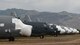 A photo of various C-130 Hercules carrier aircraft with mountains behind them