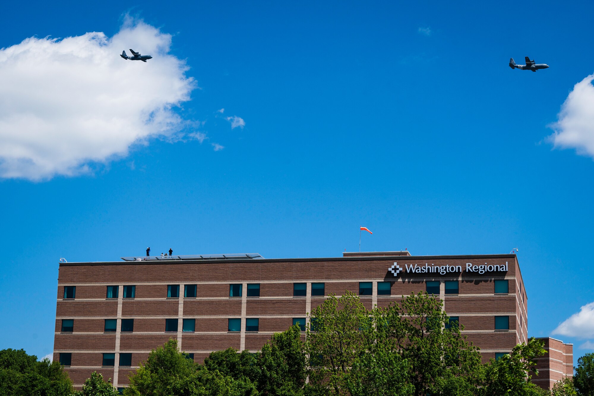 Two C-130s fly over the city