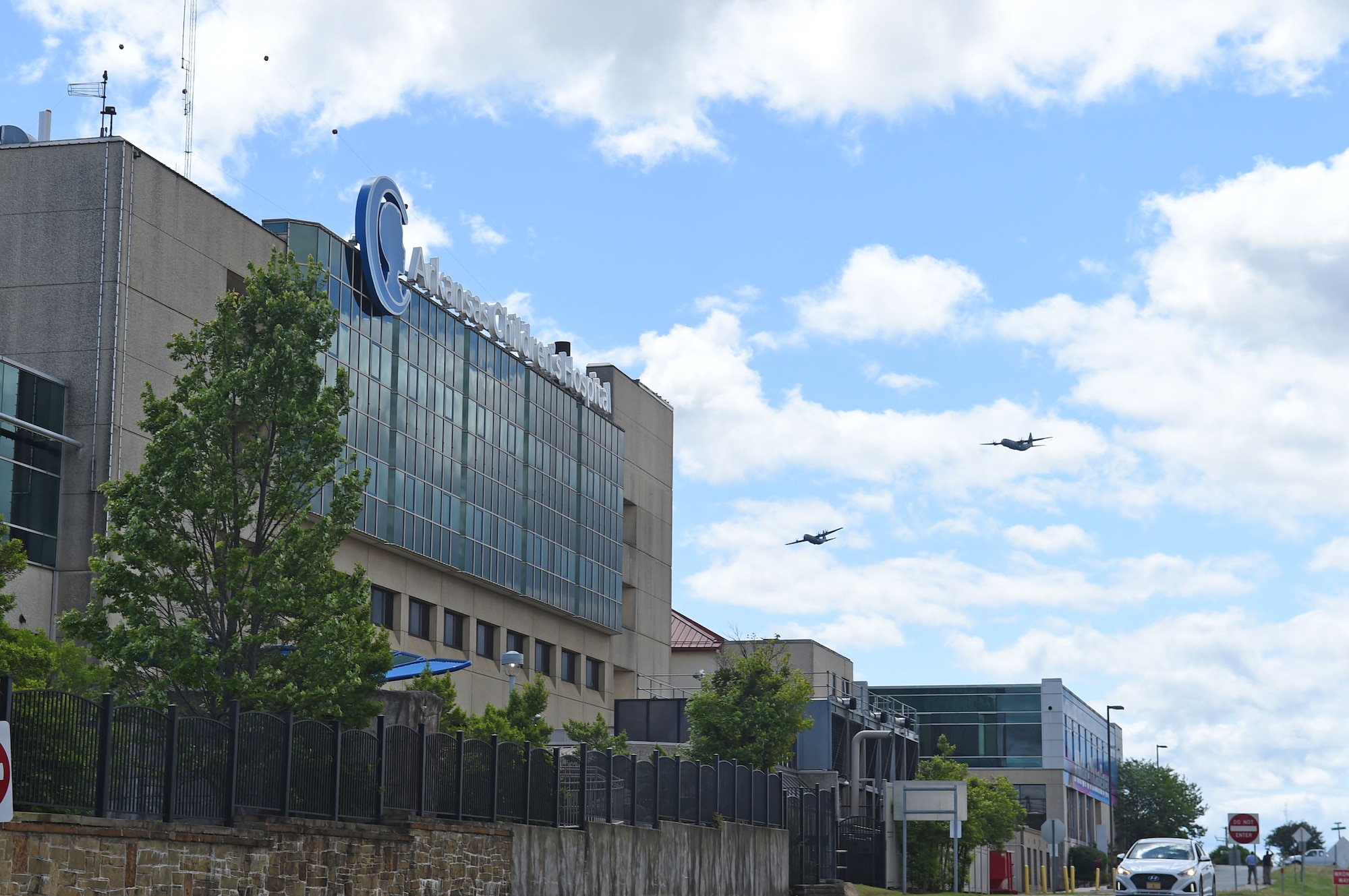 Spectators watch as two C-130s fly over the city