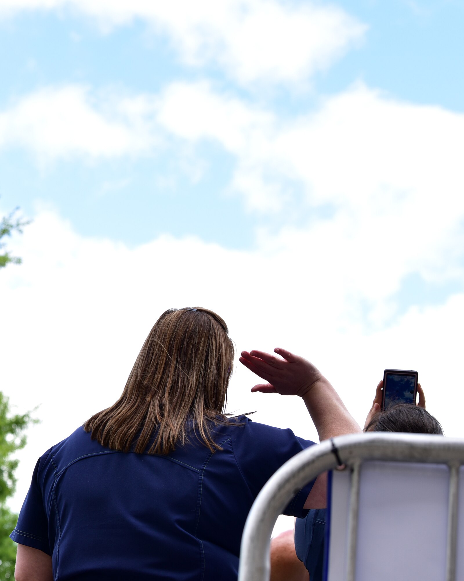 Spectators watch as two C-130s fly over the city