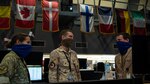 Coalition service members assigned to the Combined Air Operations Center discuss operations at Al Udeid Air Base, Qatar, April 20, 2020.