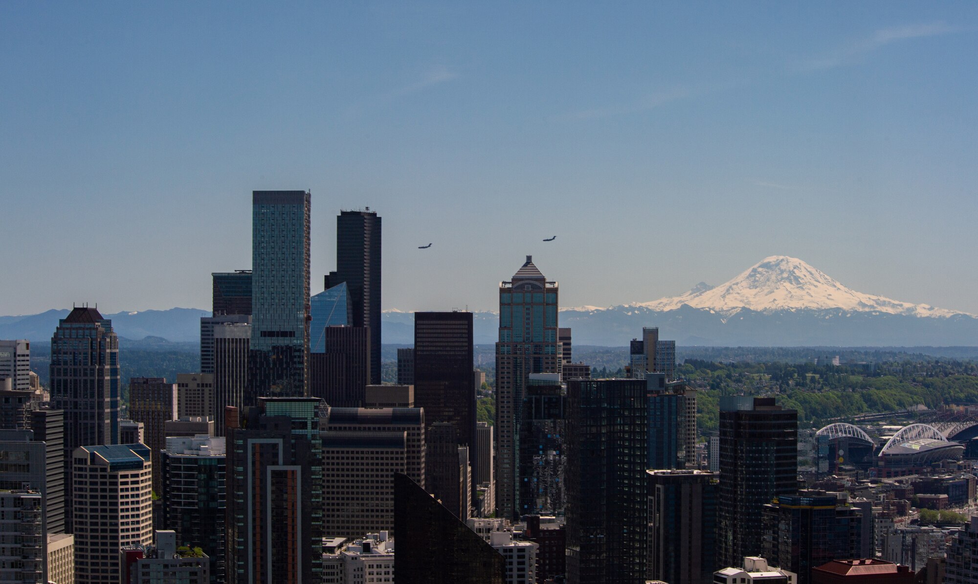 Two C-17 Globemaster IIIs assigned to 62nd Airlift Wing conduct an Air Force Salutes morale flyover in Seattle, Wash., May 8, 2020. The flyover honored the American heroes at the forefront in the fight against COVID-19. (U.S. Air Force photo by Senior Airman Tryphena Mayhugh)