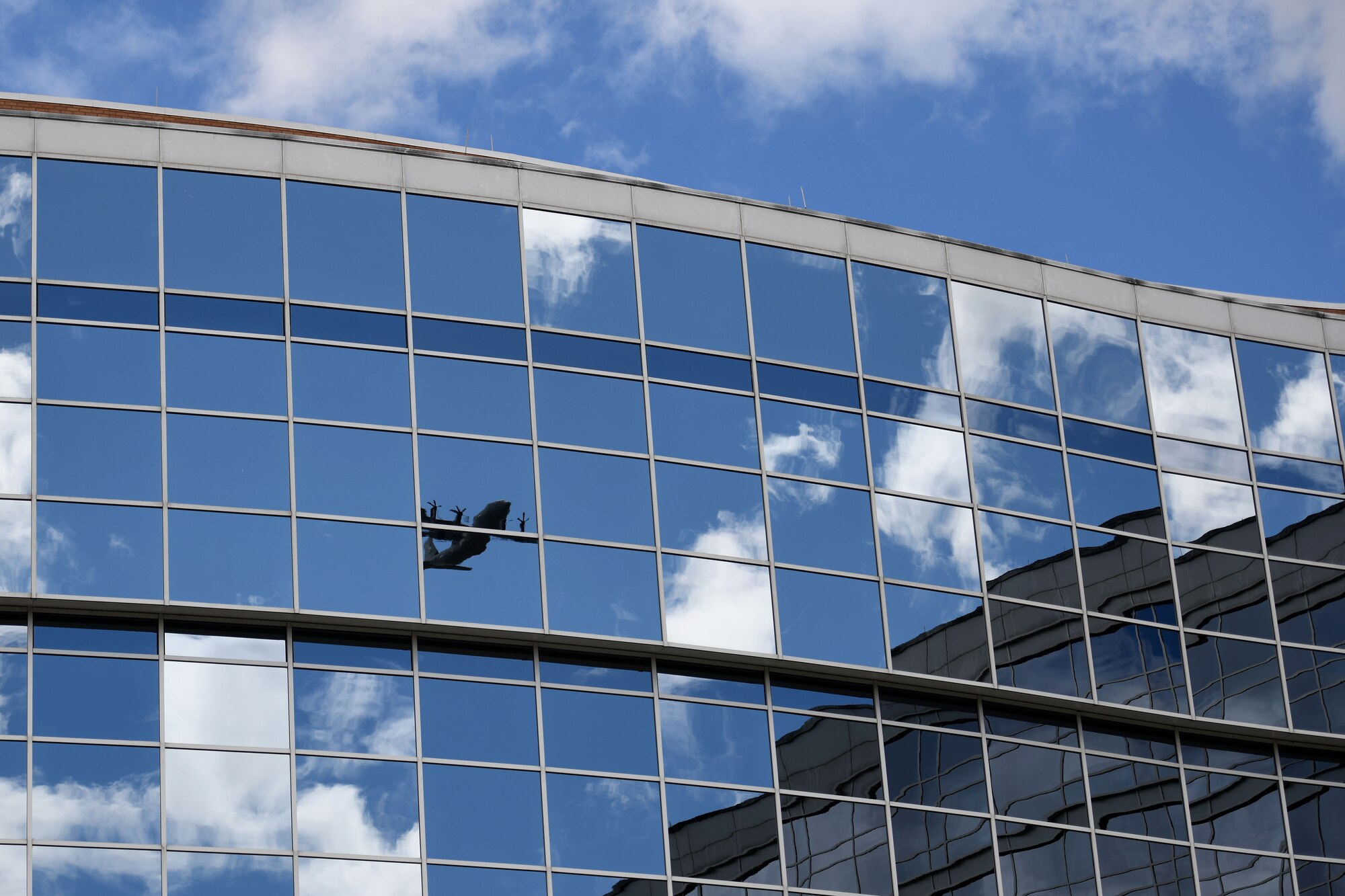 Spectators watch as two C-130s fly over the city