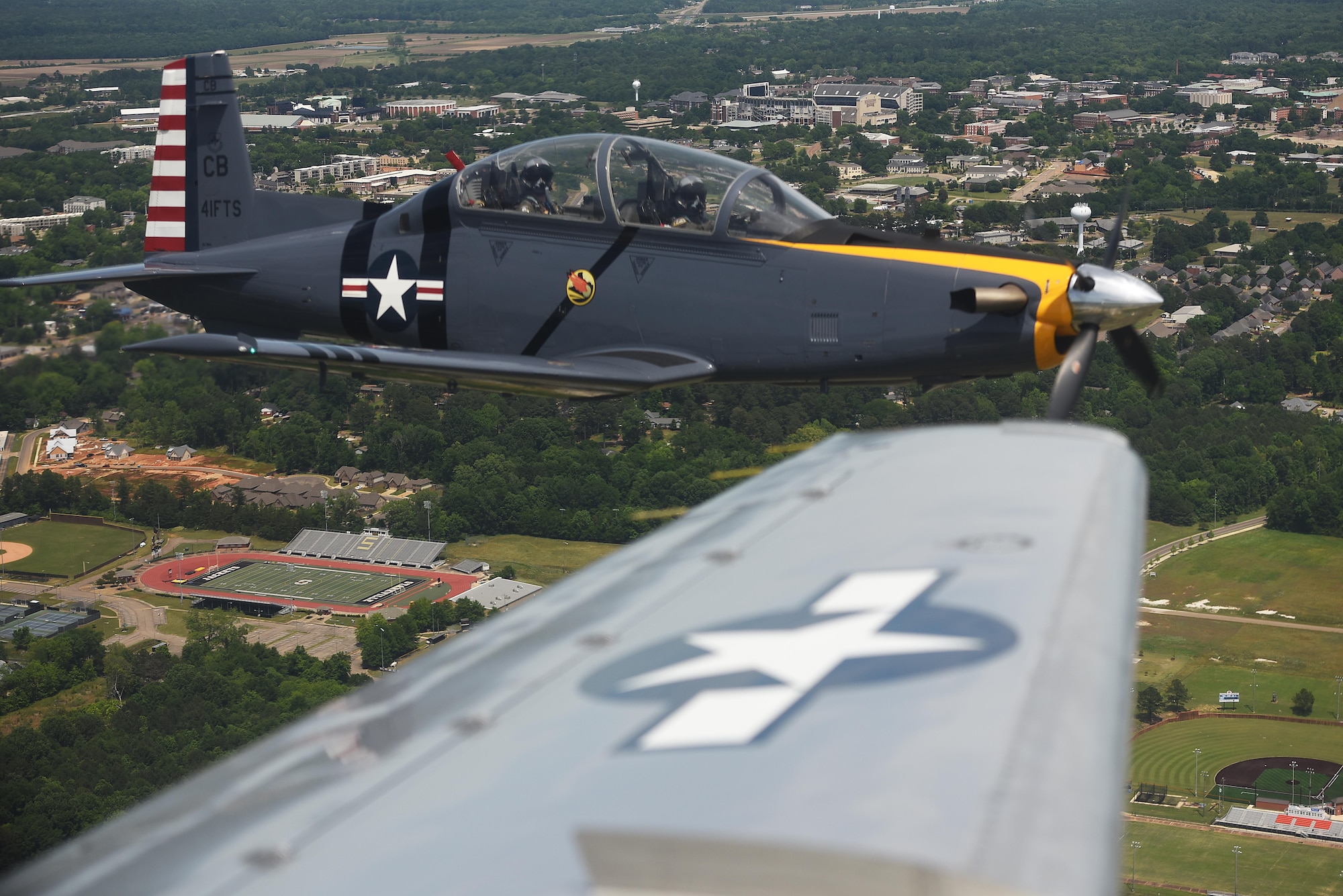 A T-6 Texan II flies in a dissimilar formation of aircraft from Columbus Air Force Base, Miss., over Starkville, Miss., May 9, 2020. The flyover was an opportunity to honor the men and women on the front lines in the fight against COVID-19 during the Defense Department’s  #AmericaStrong salute. The flyover consisted of the T-6A Texan II, T-1A Jayhawk and the T-38 Talon. (U.S. Air Force photo by Senior Airman Keith Holcomb)