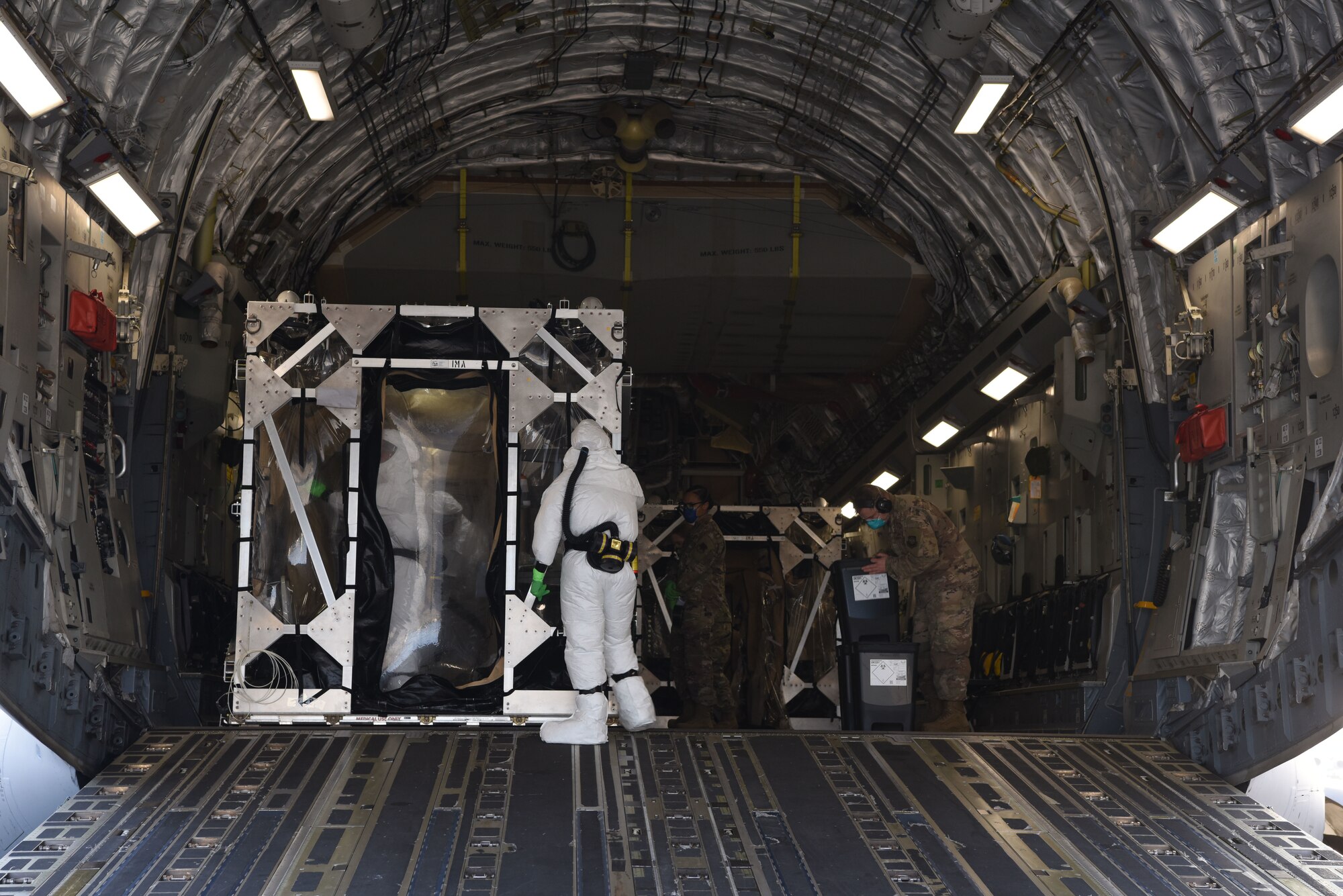 U.S. Air Force Airmen assigned to the 521st Air Mobility Operations Wing decontaminate a Transport Isolation System on a U.S. Air Force C-17 Globemaster III aircraft.