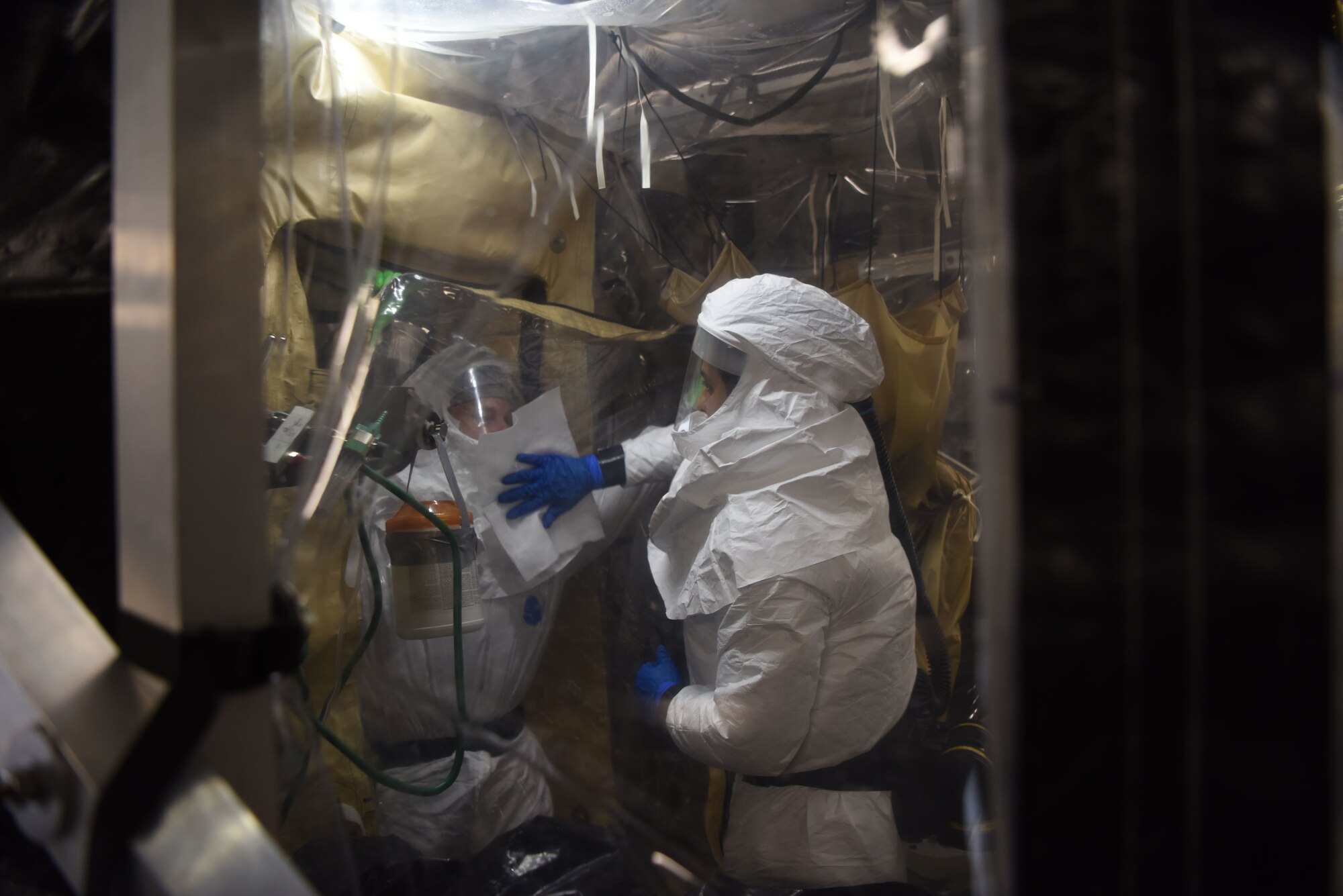 U.S. Air Force Senior Airman Jason McGhee, 313th Expeditionary Operations Support Squadron biomedical equipment technician, left, and Senior Airman Antonio Candler, 313th EOSS medical logistics, decontaminate a Transport Isolation System on a U.S. Air Force C-17 Globemaster III aircraft.
