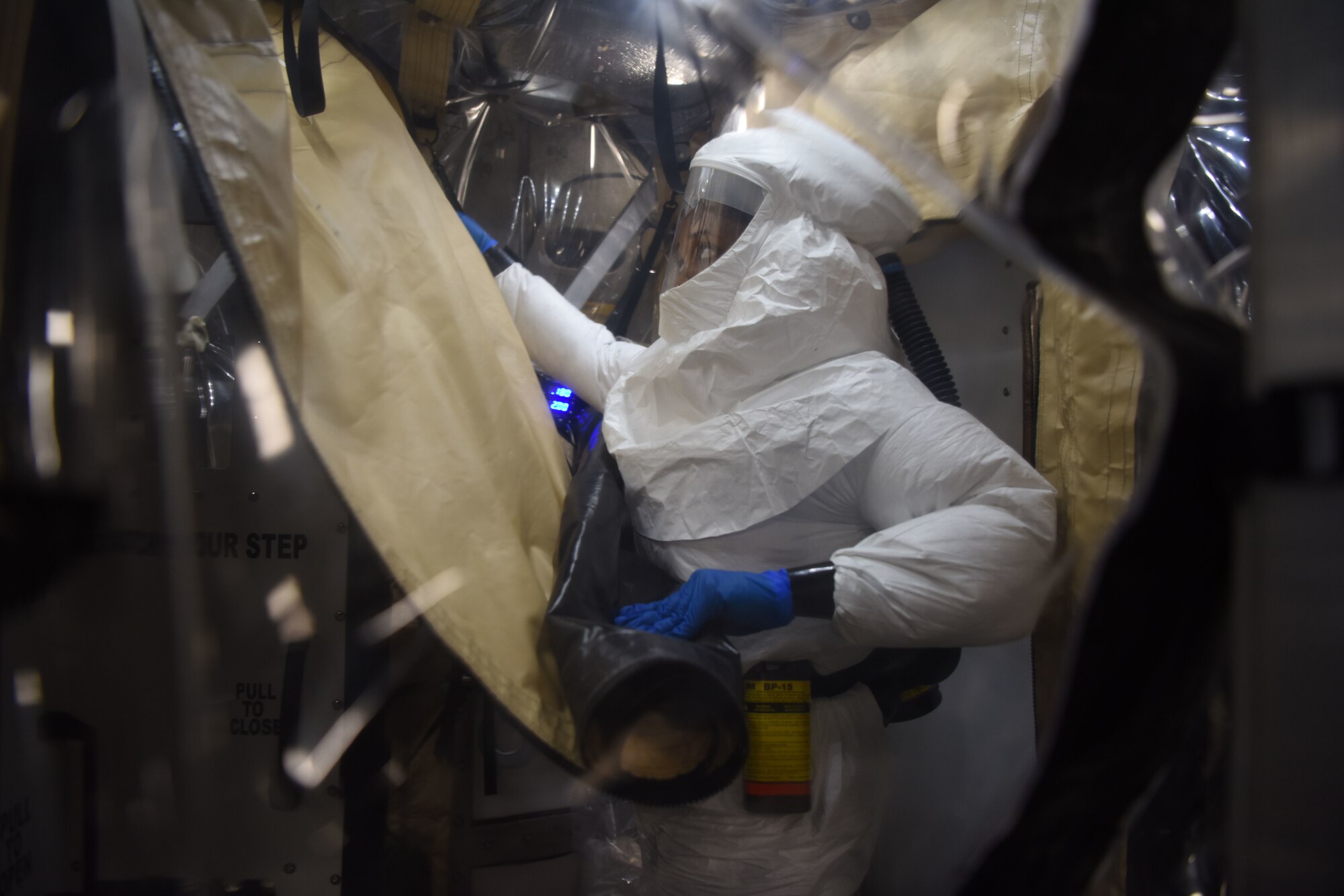 U.S. Air Force Airman 1st Class Andrea Ford, 313th Expeditionary Operations Support Squadron bio-environmental engineer, decontaminates a Transport Isolation System on a U.S. Air Force C-17 Globemaster III aircraft.