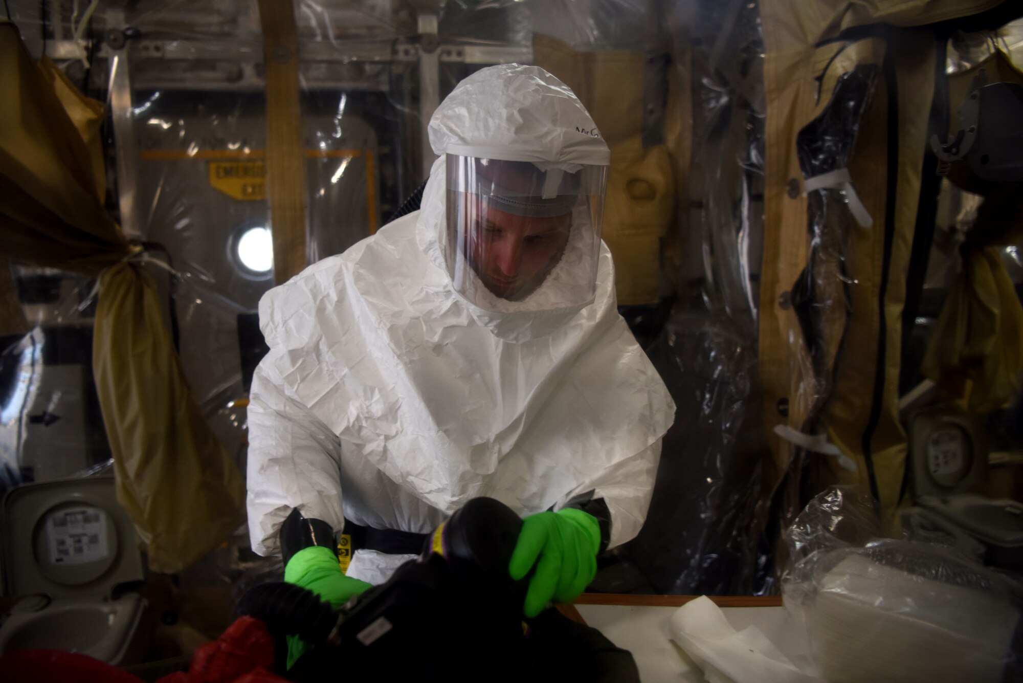 U.S. Air Force Senior Airman Jason McGhee, 313th Expeditionary Operations Support Squadron biomedical equipment technician, sanitizes a purified air respirator during the decontamination of a Transport Isolation System on a U.S. Air Force C-17 Globemaster III aircraft.