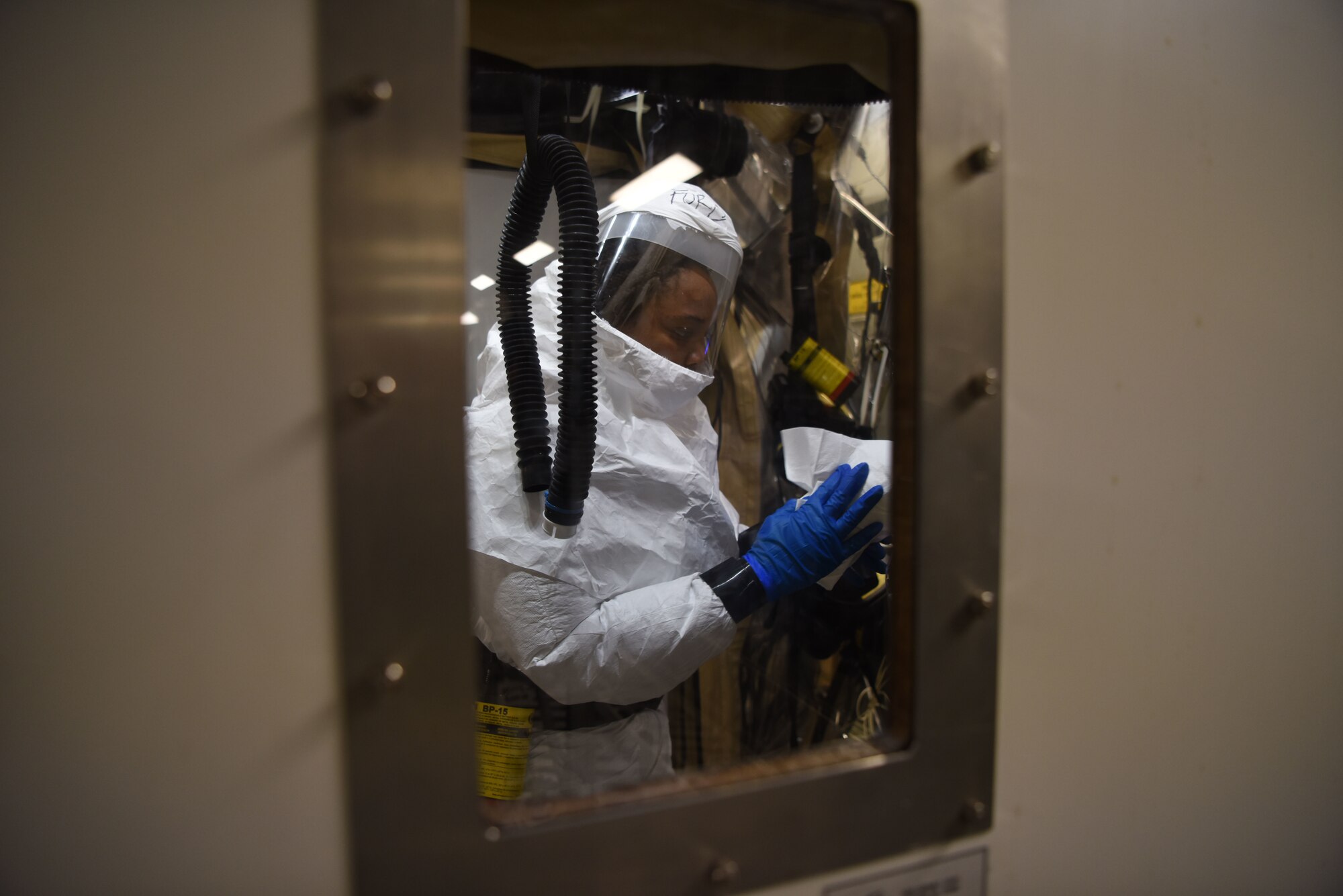U.S. Air Force Airman 1st Class Andrea Ford, 313th Expeditionary Operations Support Squadron bio-environmental engineer, decontaminates a Transport Isolation System on a U.S. Air Force C-17 Globemaster III aircraft.