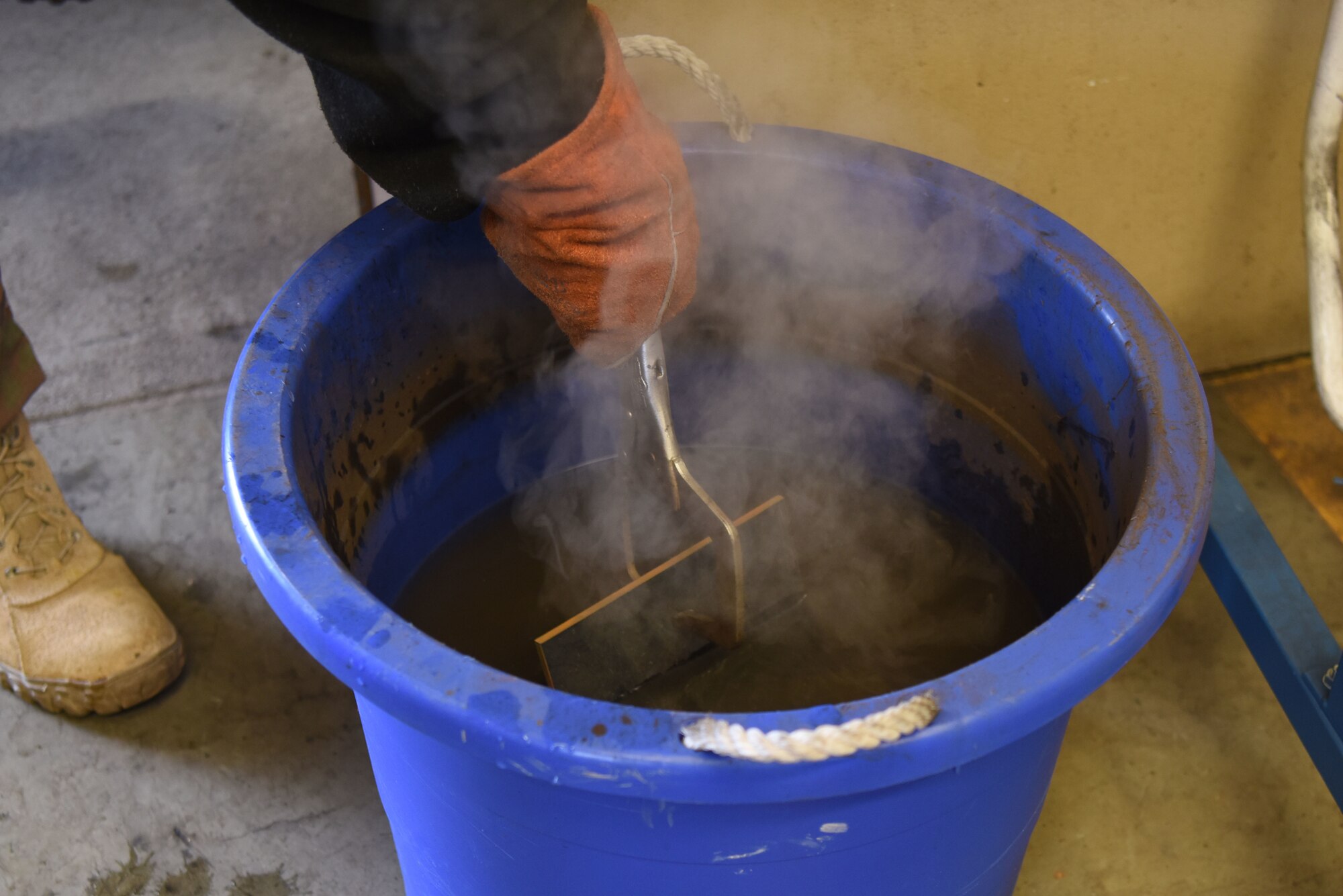 A U.S. Airman assigned to the 786th Civil Engineer Squadron cools off a piece of metal during a welding course.