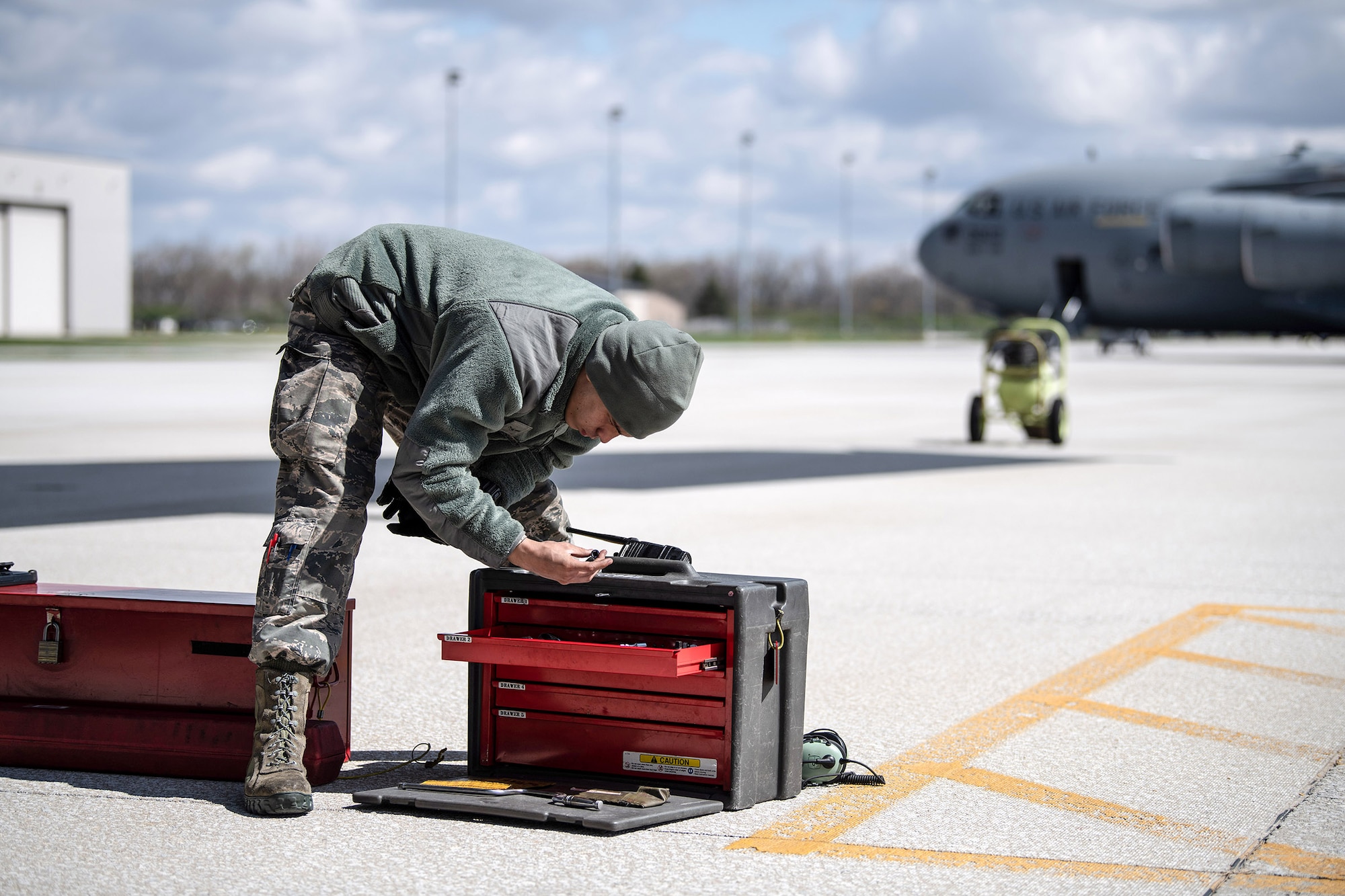Airman 1st Class Luis Ramirez-Rosado, 445th Aircraft Maintenance Squadron, retrieves tools from his toolbox prior to changing tires on a  C-17 Globemaster III here April 9, 2020. (U.S. Air Force photo/Mr. Patrick O’Reilly)