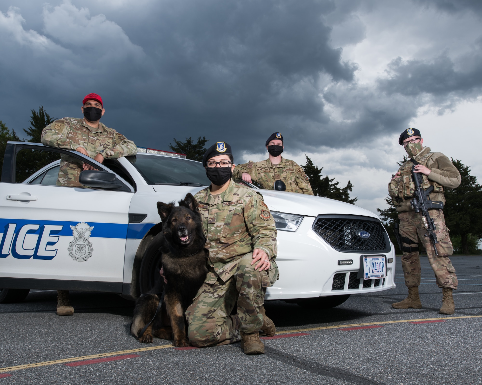 (From left) Staff Sgt. Jose Bracero-Camareno, 436th Security Forces Squadron combat arms instructor; Senior Airman Theresa Braack, 436th SFS military working dog handler with MWD Terry; Staff Sgt. Kirk Savage, 436th SFS Raven team leader and Senior Airman Ryan Claiborn, 436th SFS installation patrolman, stand next to a patrol vehicle May 8, 2020, at Dover Air Force Base, Delaware. The 436th SFS will host events for Police Week 2020 to honor fallen defenders. (U.S. Air Force photo by Mauricio Campino)